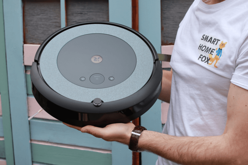 A robot vacuum cleaner is held up to see.